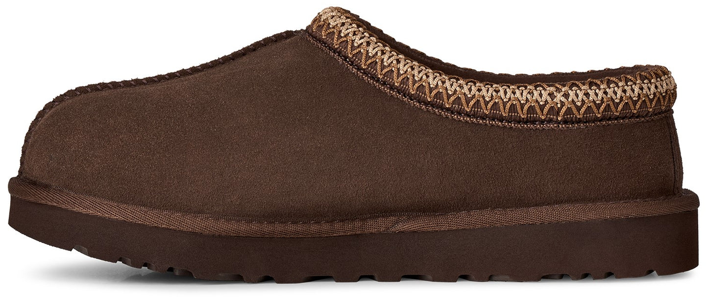 A brown suede slip-on slipper with a decorative woven trim around the collar and a thick rubber sole.