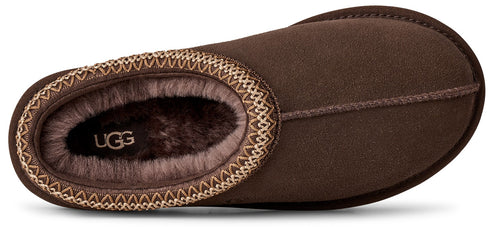 A brown suede slipper viewed from directly above, featuring a decorative woven trim around the opening and a plush brown faux fur lining with the text UGG visible on the heel.