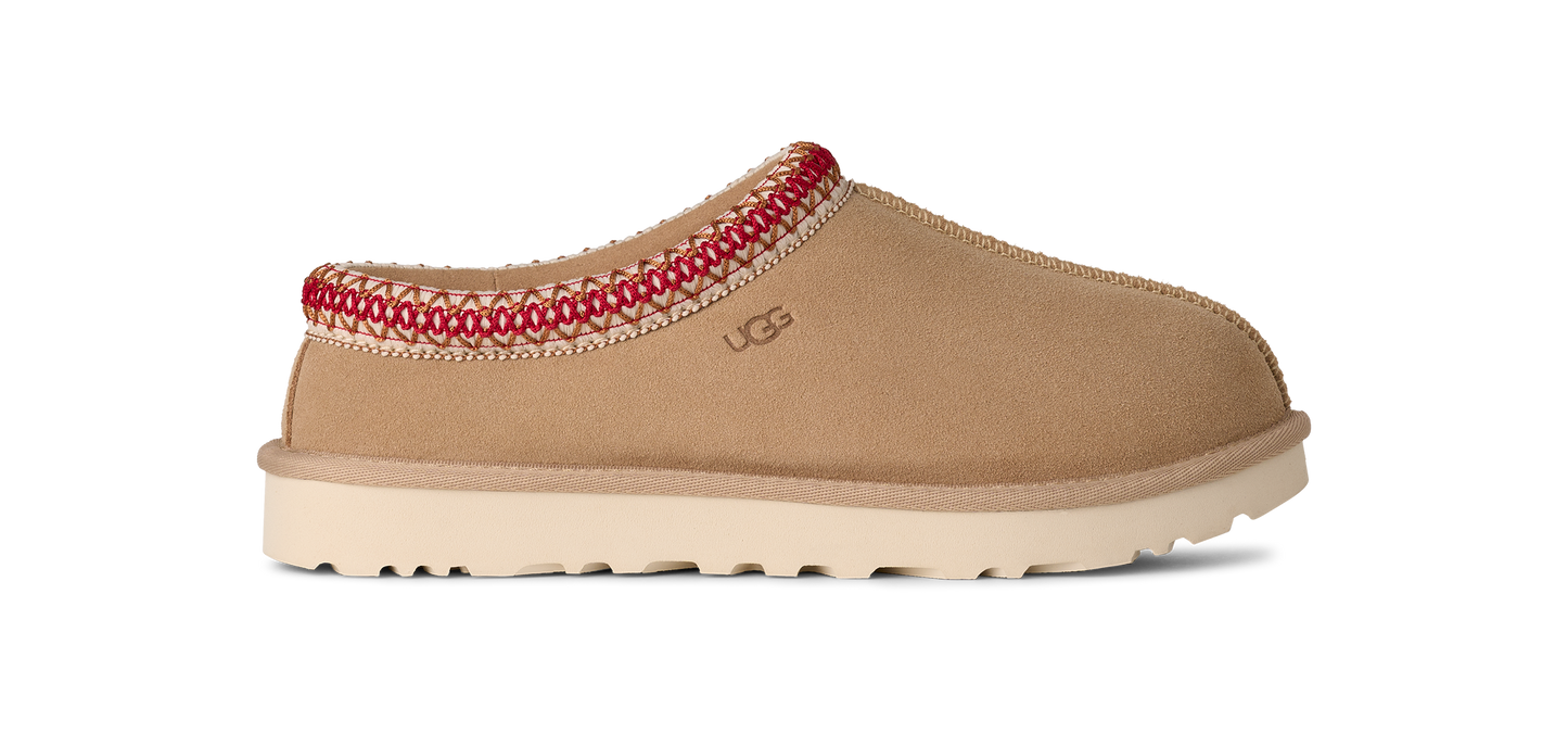 Slip-on shoe in tan with white sole and red stitching around the opening.