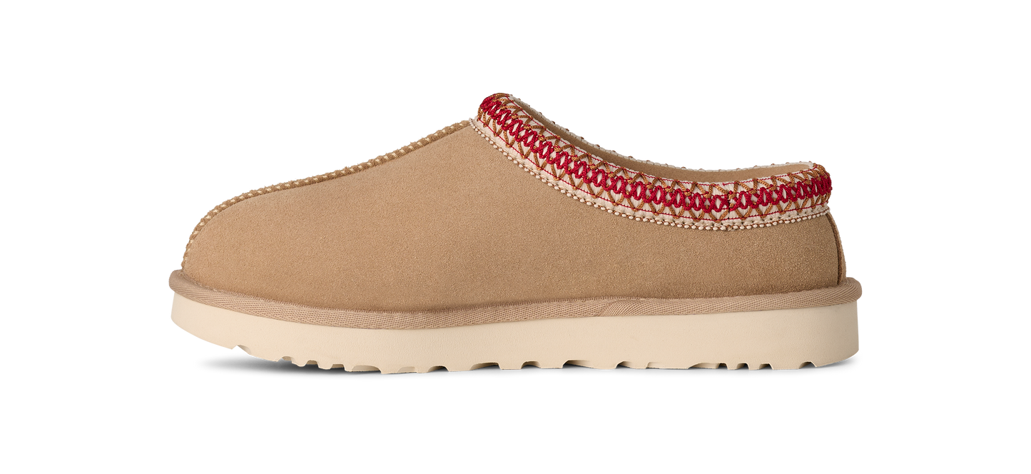 Tan-colored slipper with red stitching along the top edge and a white sole.