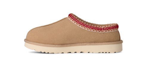 Tan-colored slipper with red stitching along the top edge and a white sole.