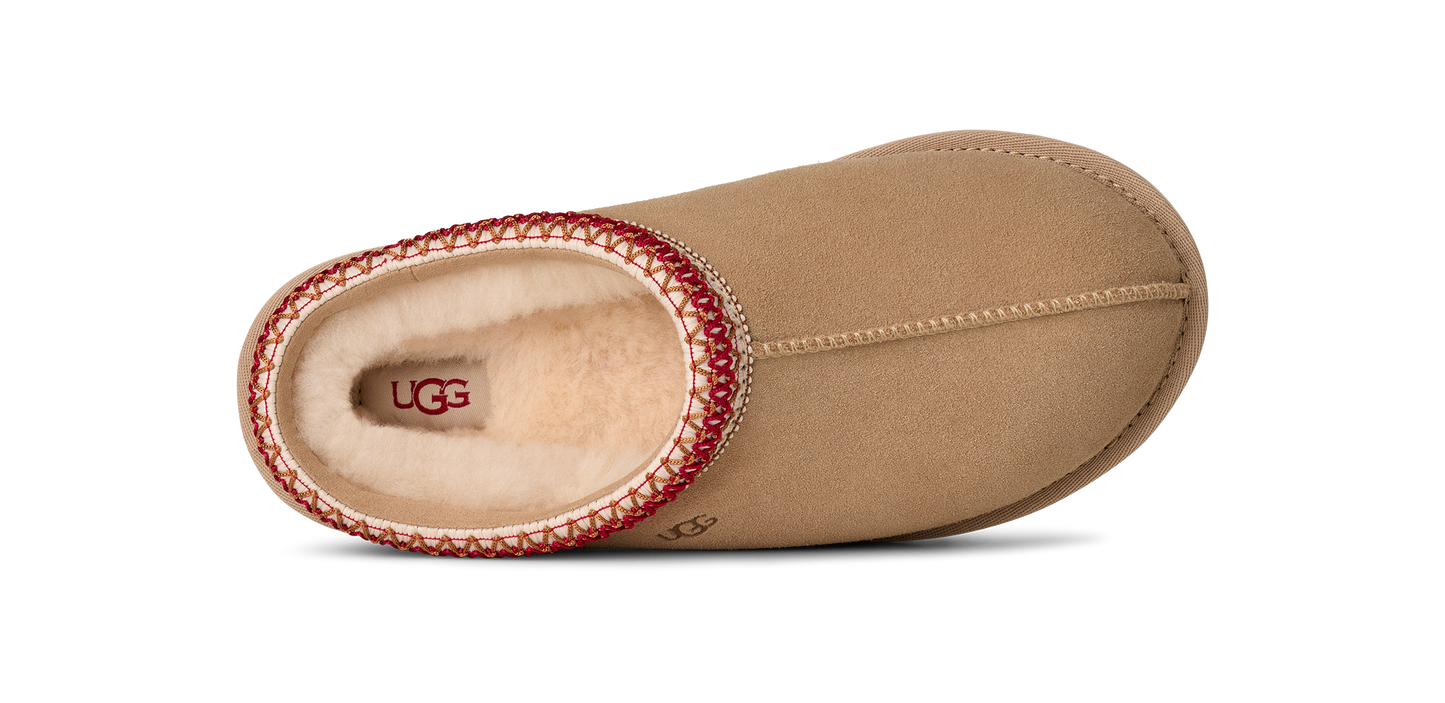 Top-down view of a brown slip-on shoe with a red and cream braided trim.