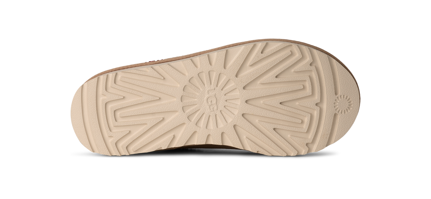 The underside of a shoe displays a grooved, beige-colored sole.