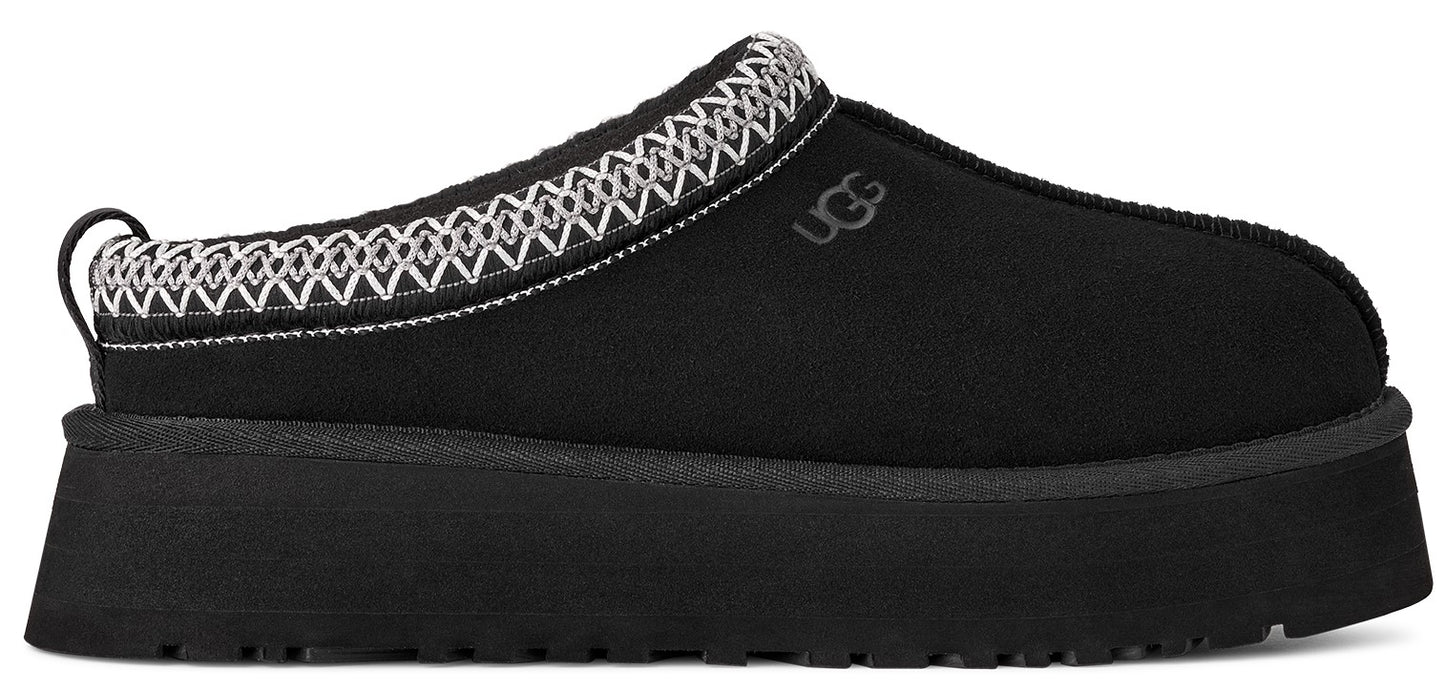A black slip-on shoe with a thick sole and white decorative trim.