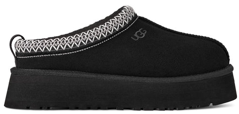 A black slip-on shoe with a thick sole and white decorative trim.
