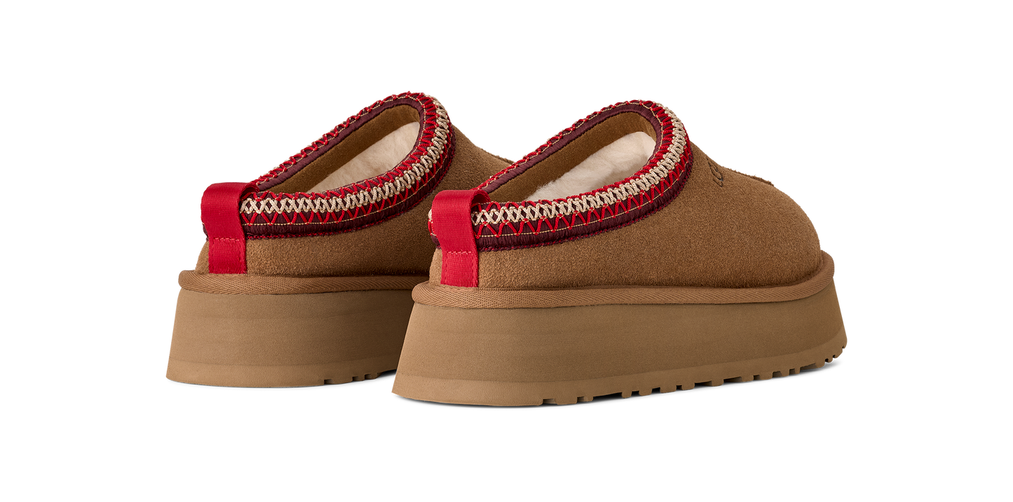 A pair of brown platform shoes with a red and white band around the opening.