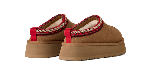 A pair of brown platform shoes with a red and white band around the opening.
