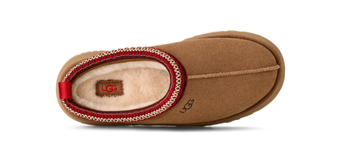 Tan UGG slipper with red and white trim.