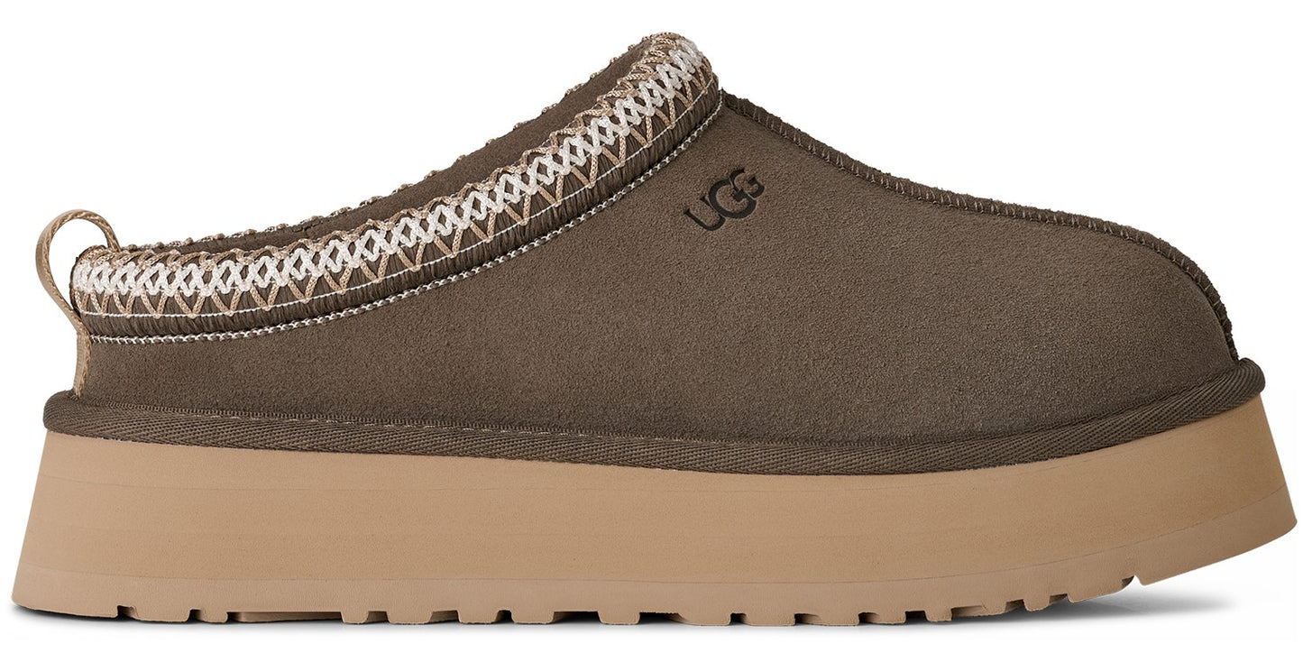 Side view of a brown suede mule with a platform and decorative trim.