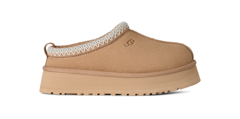 A tan, slip-on shoe with a thick sole and a zig-zag design around the top opening.