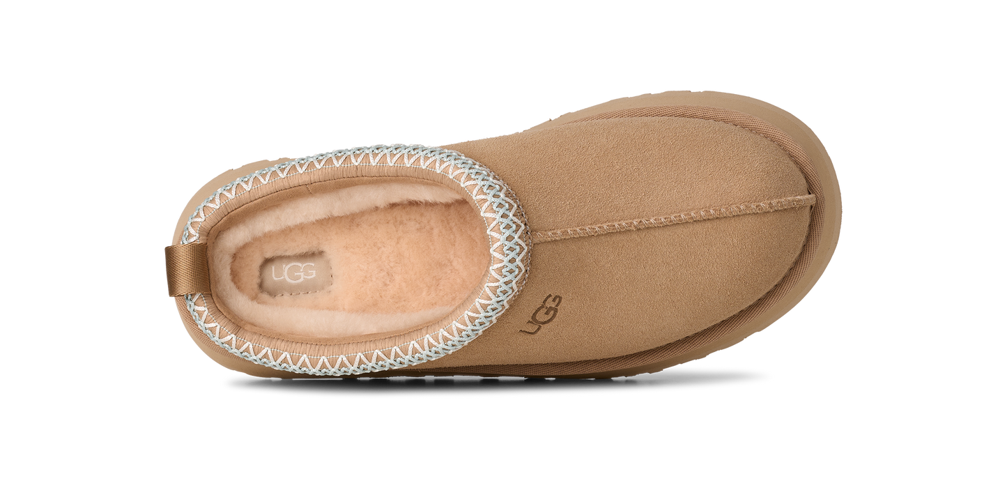 Tan colored slip-on shoe with decorative white stitching.