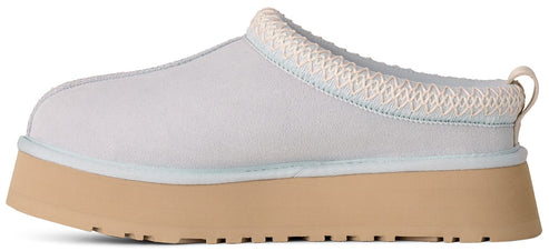 A light grey, suede-like slip-on shoe with a thick, tan, platform rubber sole and a braided trim around the opening.