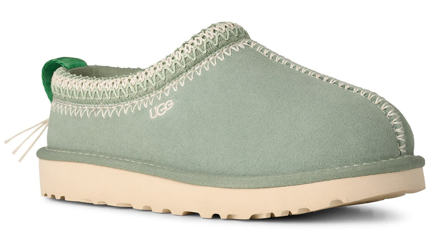 Light green slip-on shoe with a cream-colored sole and a green pull tab, with UGG logo on the side.