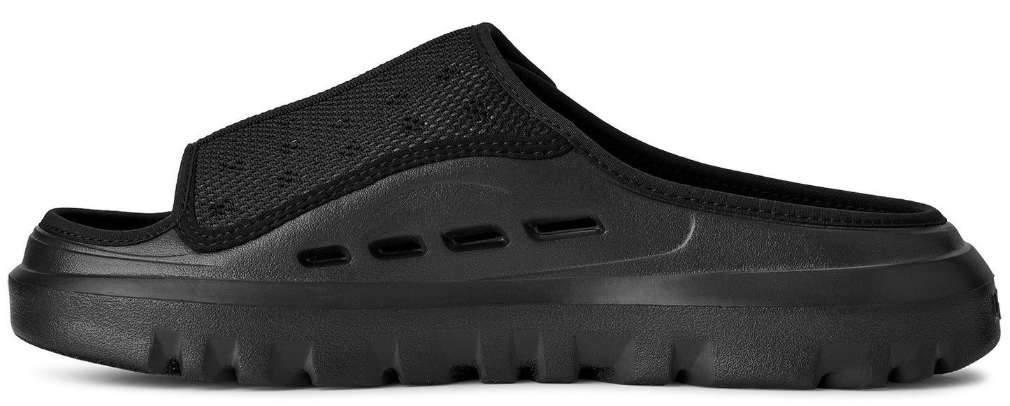 A black slide sandal featuring a textile vamp and a lug sole.