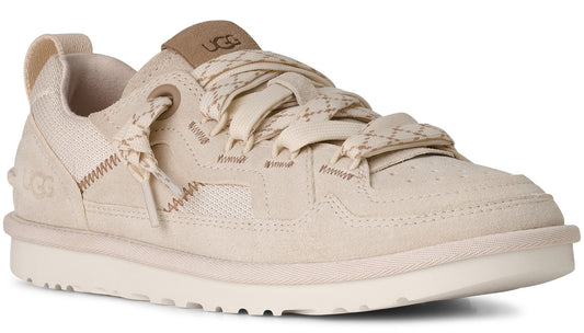 A low-cut, tan-colored sneaker with a flat sole and patterned laces.