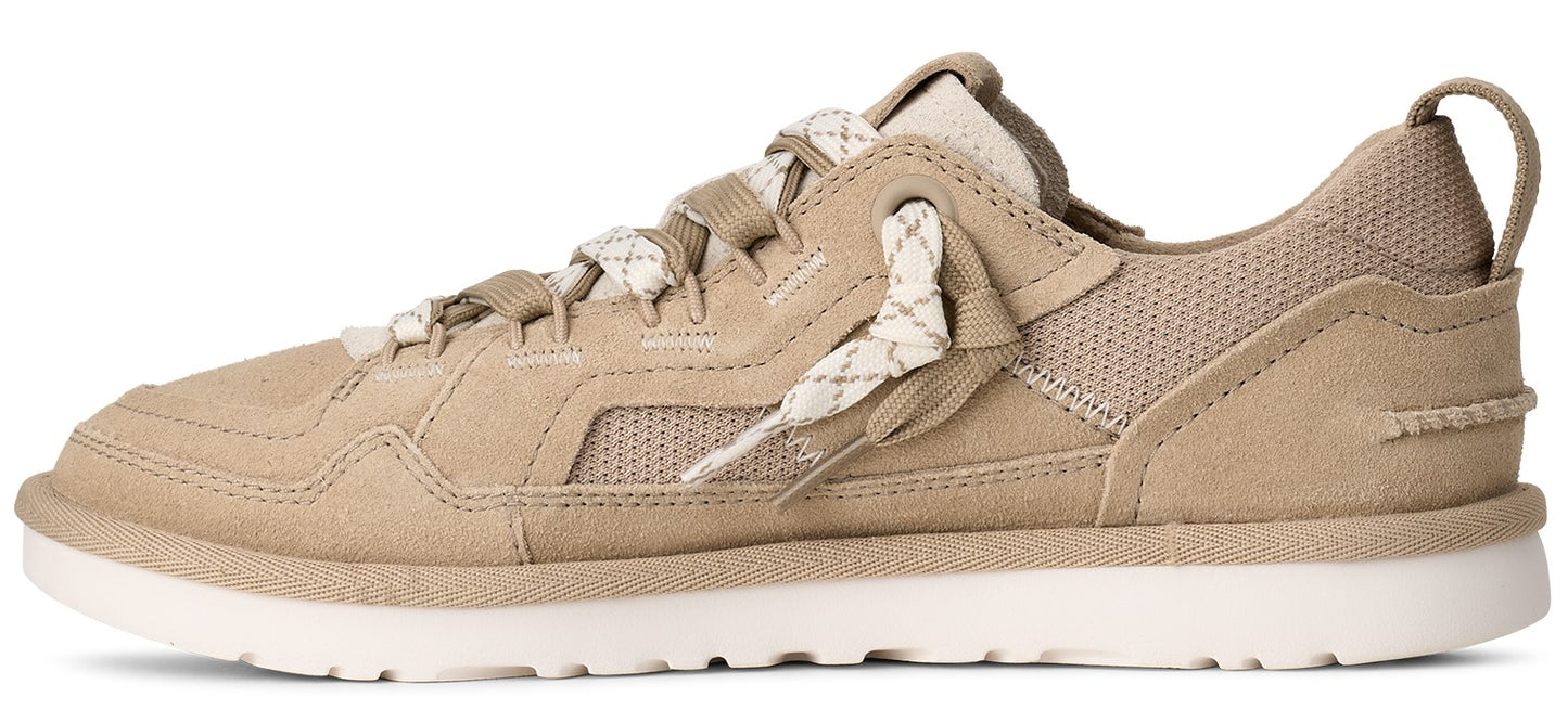A tan sneaker with white soles and patterned laces.