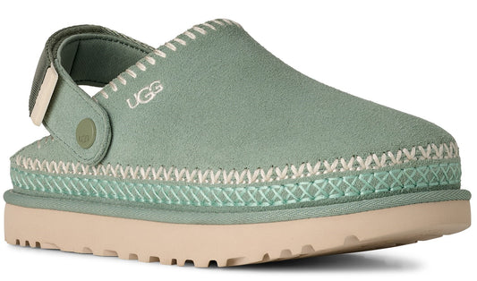 Ugg Tasman Slipper with visible UGG text, soft green upper with white stitching, adjustable strap, beige sole.