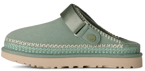 A light green clog-style shoe with a khaki sole, featuring stitching and a strap.