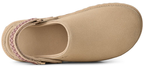 Top-down view of a light beige suede clog-style slipper with a decorative pink and tan patterned fabric heel strap against a plain white background.