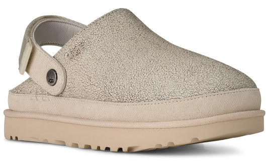 Beige clog-style shoe with a textured upper, a cream-colored sole and a back strap with a button.