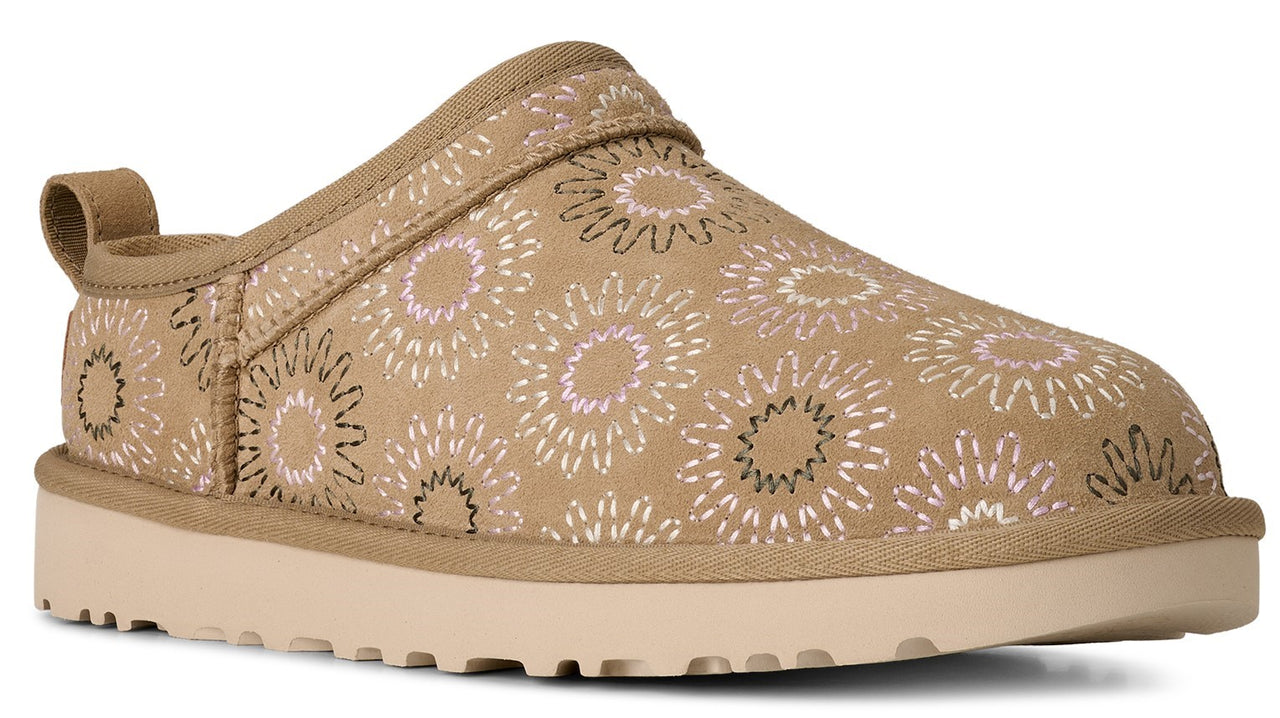 Tan slip-on shoe with stylized flower pattern, tan sole, and heel loop.