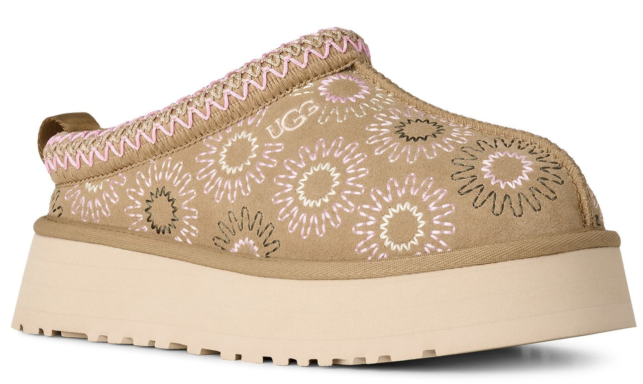 Slip-on shoe in tan with pink and black floral designs and a light beige platform sole.