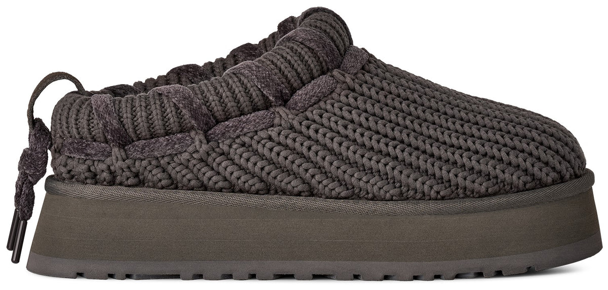 A dark charcoal grey, thick-soled, slip-on platform shoe with a knit-texture upper and a decorative braided drawstring detail at the heel.