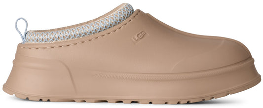 A tan slip-on shoe with a thick platform sole, a rounded toe, a light blue knitted collar, and a pull tab at the heel, featuring the brand name UGG embossed on the side.
