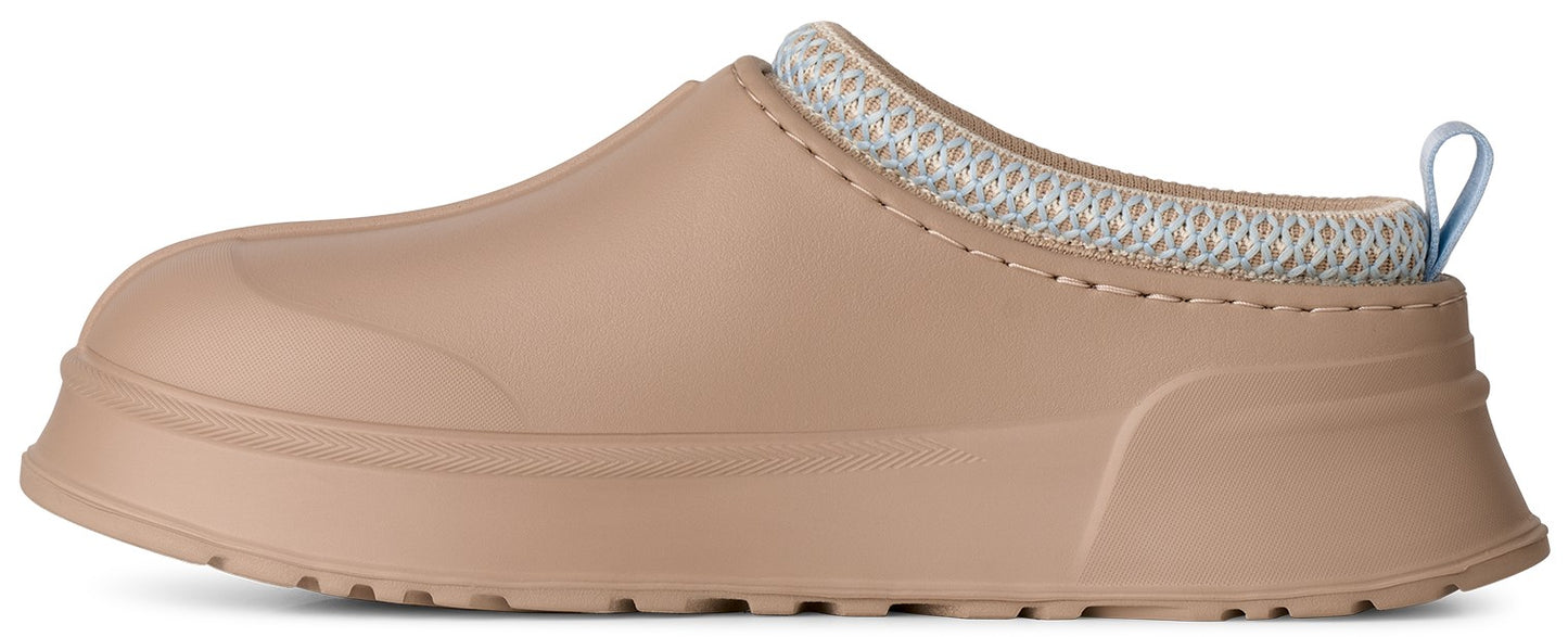A tan slip-on shoe with a thick platform sole and a textured, light-colored fabric rim around the collar.