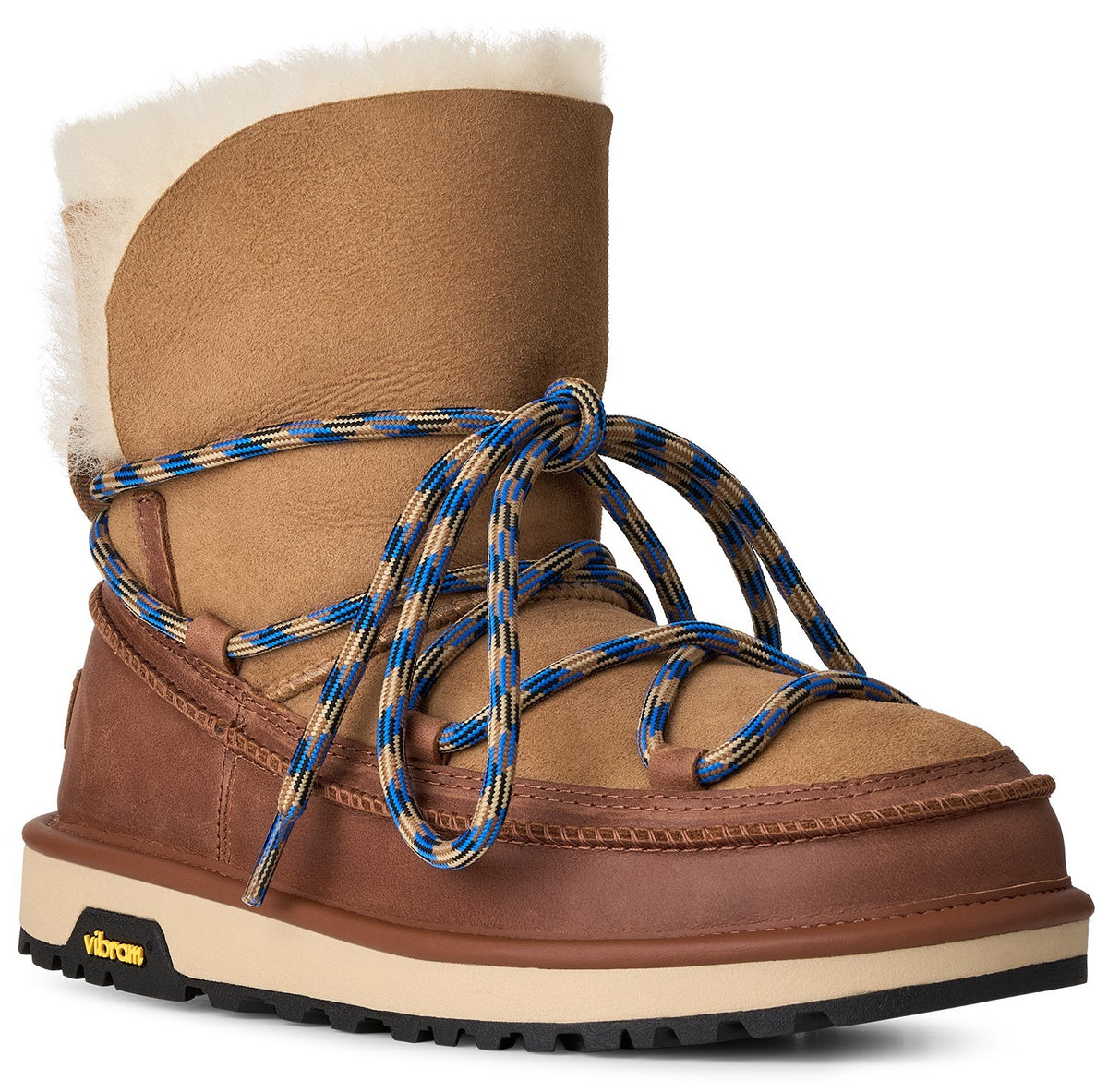 A tan suede winter boot featuring a cream-colored shearling lining, a thick brown rubber rand, a cream and black Vibram sole, and blue and tan patterned rope laces wrapped around the ankle.