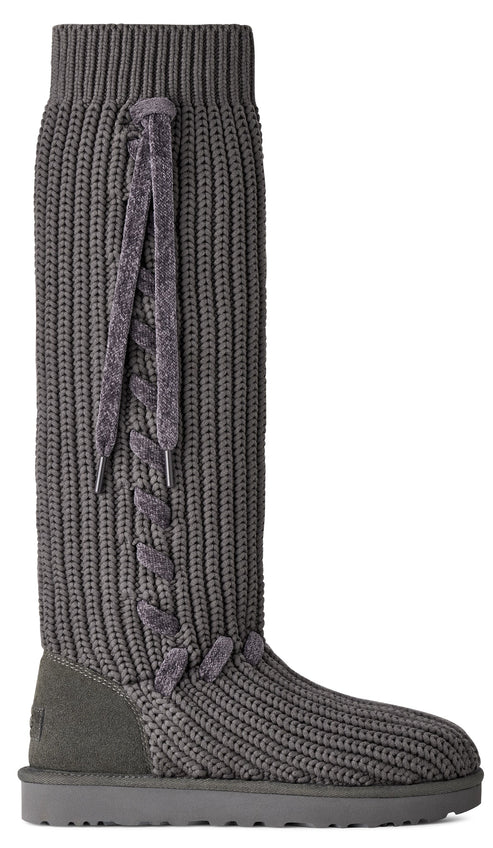 A tall, charcoal-grey knitted boot with a ribbed texture, featuring a vertical decorative velvet lace-up detail along the side and a smooth suede heel counter.