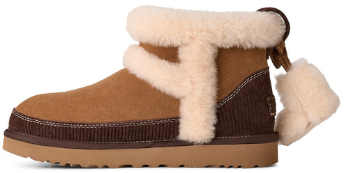 A tan suede and dark brown corduroy ankle boot with a light cream-colored shearling trim and a matching fluffy pom-pom detail on the back.