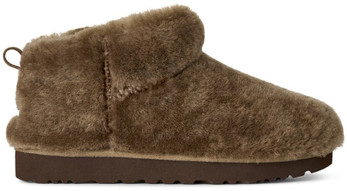 A brown faux fur slip-on ankle boot with a rounded toe, a folded collar, a pull tab at the heel, and a flat, dark brown rubber sole.