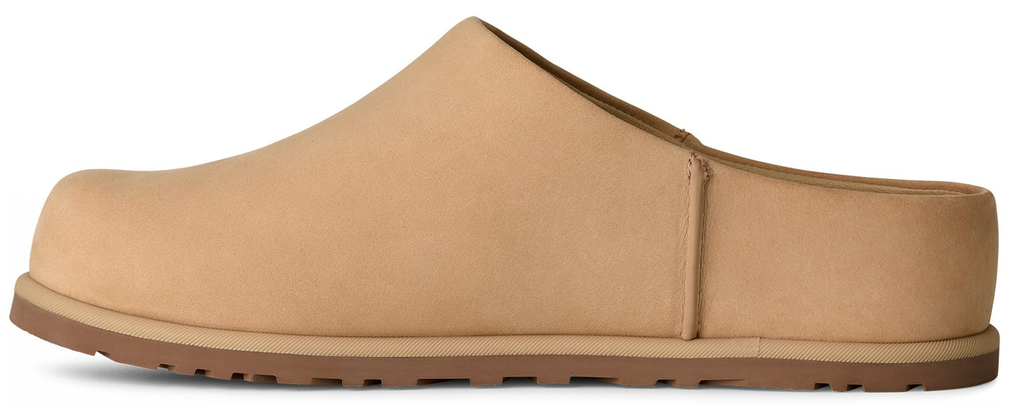 A tan suede slip-on mule shoe with a rounded toe and a brown flat rubber outsole shown from a side view.