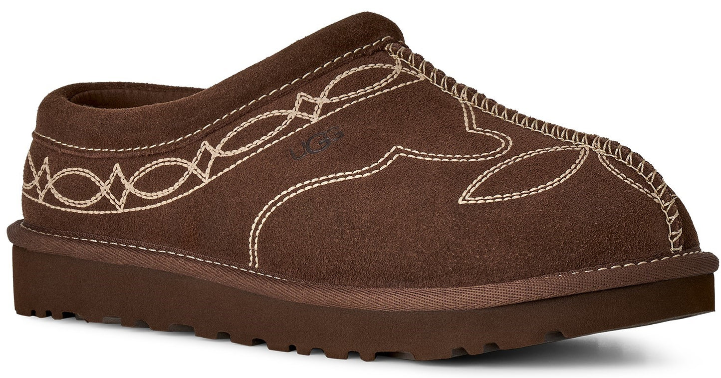 A brown suede mule slipper with a thick brown sole and decorative white contrast stitching in a western-inspired pattern on the upper.