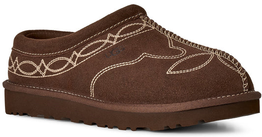 A brown suede mule slipper with a thick brown sole and decorative white contrast stitching in a western-inspired pattern on the upper.