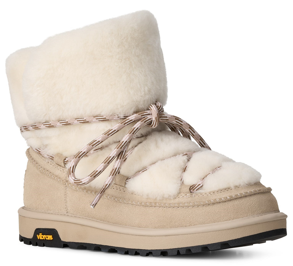 A beige suede and off-white faux fur ankle winter boot with a crisscross lace-up design and a thick, lugged black Vibram rubber outsole.