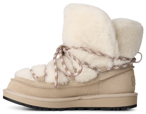 A tan suede winter boot with a thick cream-colored shearling lining, featuring decorative rope laces wrapped around the ankle and a dark lugged rubber sole.