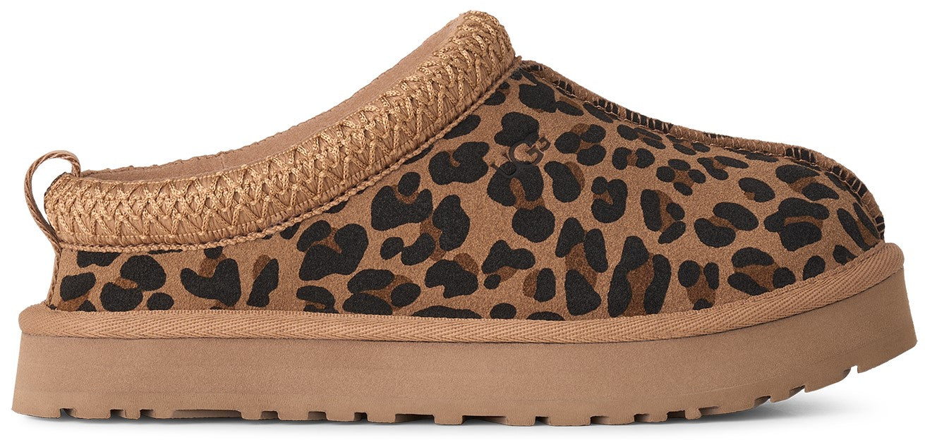 A slip-on shoe with a brown leopard print upper, a thick tan platform sole, and a woven tan trim around the collar.