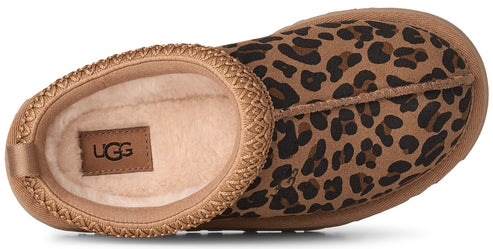 A slip-on slipper with a leopard print upper, a thick braided trim along the collar, and an interior lined with light-colored fleece, showing an UGG brand label inside.