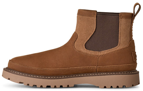 A tan Chelsea boot with a smooth suede upper, brown elastic side panels, a rear pull tab, and a thick, lugged, light brown rubber outsole.