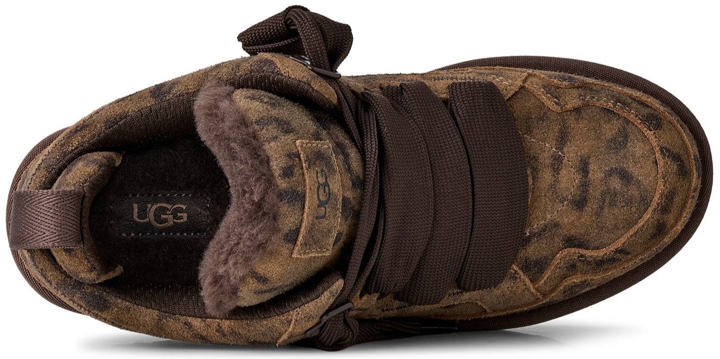 A top-down view of a brown leopard-print suede sneaker with wide dark brown ribbon laces, featuring a plush sheepskin lining and an UGG logo patch on the tongue and insole.