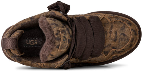 A top-down view of a brown leopard-print suede sneaker with wide dark brown ribbon laces, featuring a plush sheepskin lining and an UGG logo patch on the tongue and insole.