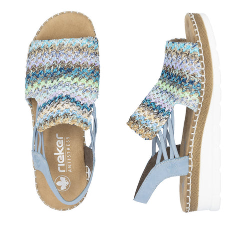 Two blue sandals, one viewed from above, the other from the side. The sandal has a white platform sole and a woven multicolored upper section.
