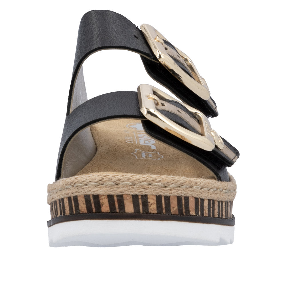 Black sandal with two large gold buckles and a striped platform sole.