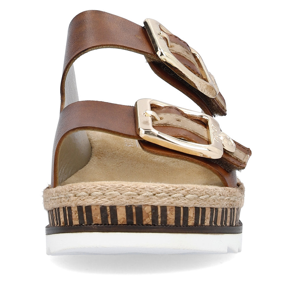 Close-up of a brown sandal with two wide straps and gold buckles on a platform sole with rope trim.
