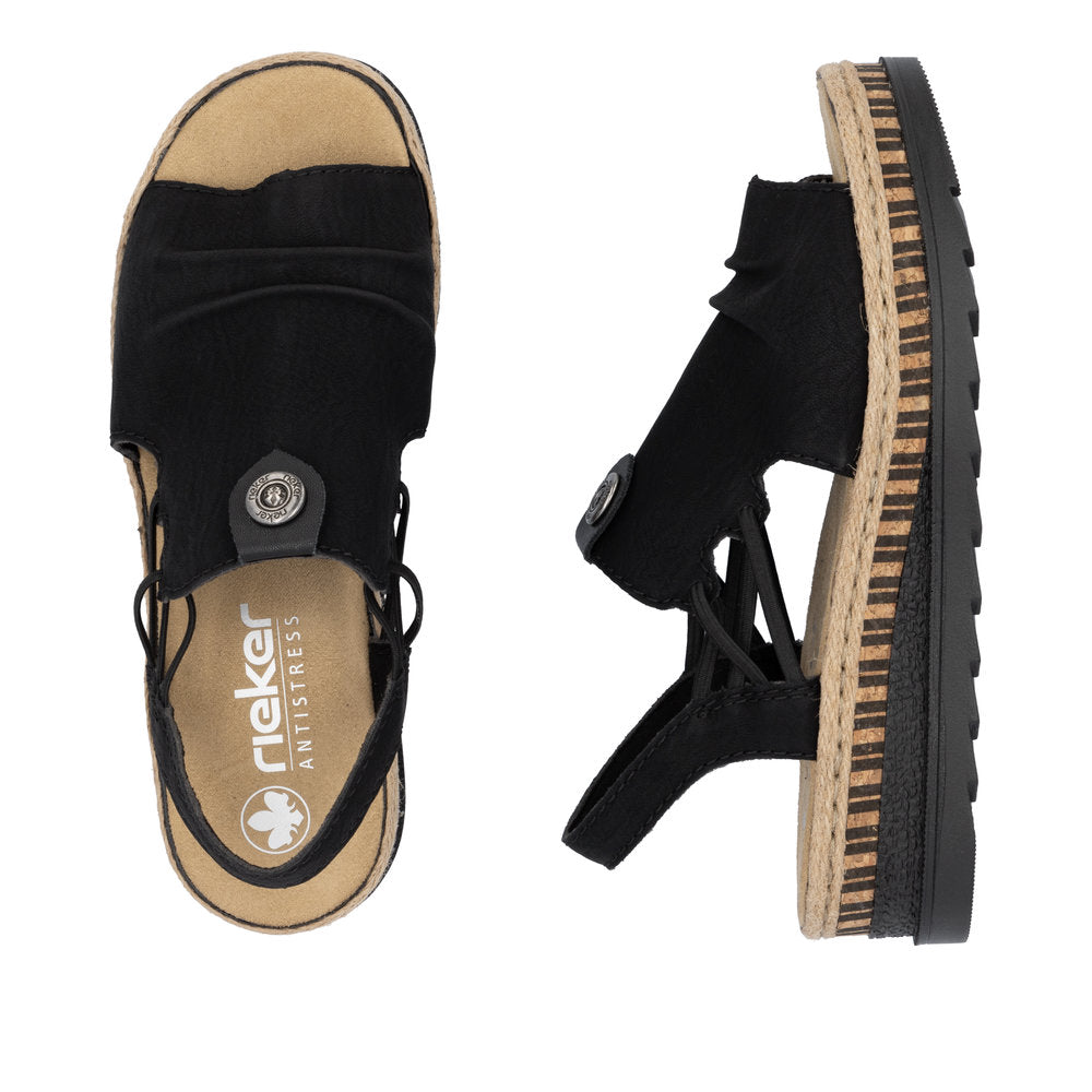 Two black rieker brand sandals with visible decorative buttons and rubber and faux wood soles.