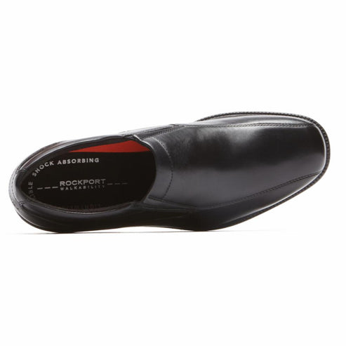 Black leather shoe with rounded square toe, red insole with white text reads "SHOCK ABSORBING ROCKPORT WALKABILITY".