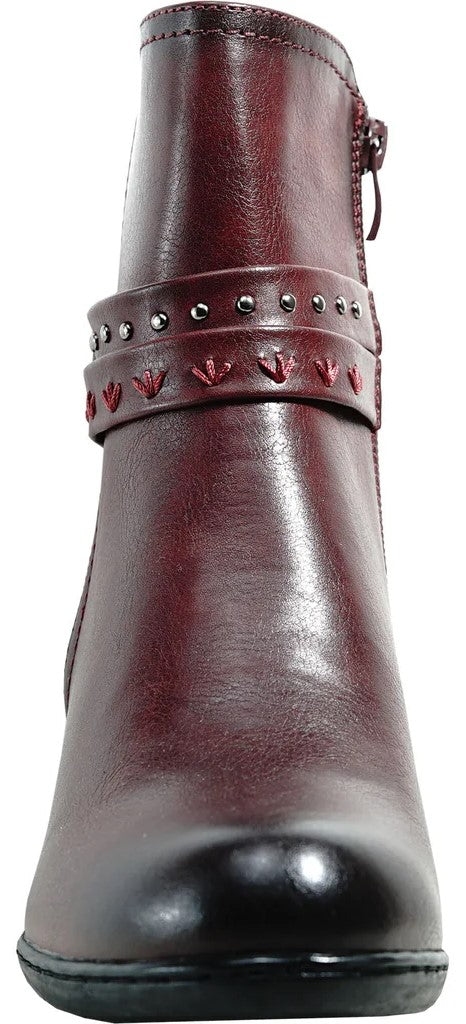 A maroon ankle boot with a rounded toe, featuring a strap across the ankle decorated with silver studs and small, triangular cut-outs, finished with a subtle black gradient at the toe and a side zipper.