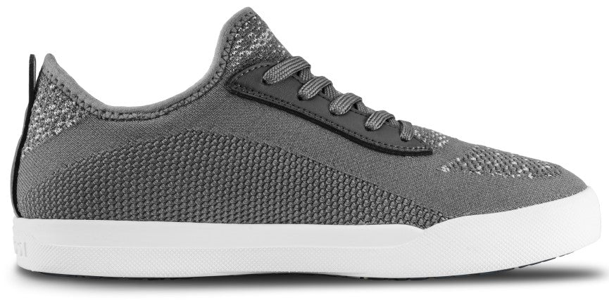 A low-top, lace-up sneaker in a grey knit fabric, featuring a dark grey eyelet panel and a thick white rubber sole.